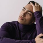 Hombre joven con mirada pensativa y preocupada, reflexionando sobre cómo dejar de sentirse un fracaso y recuperar su autoestima.