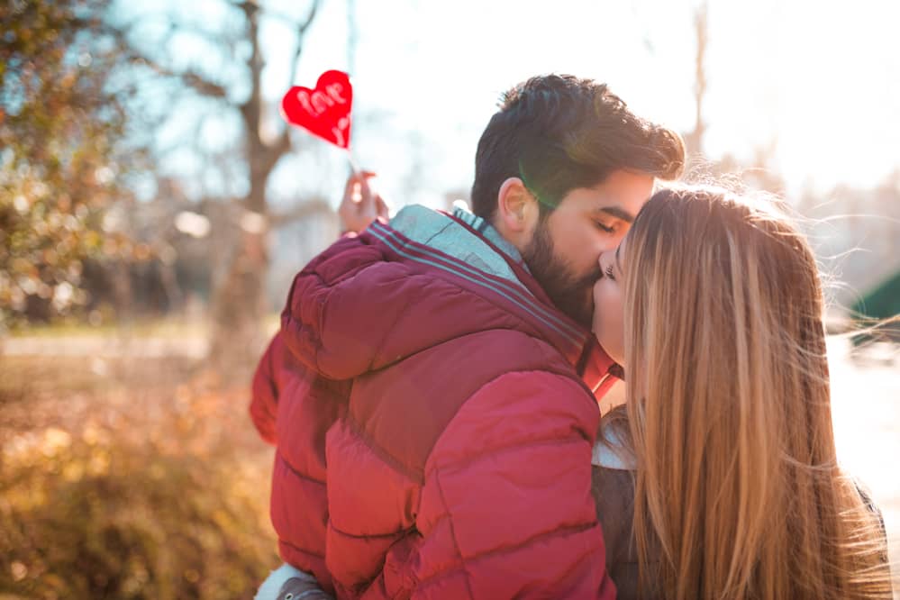 Elegante pareja besándose al aire libre